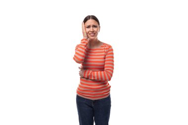 Siyah saçlı beyaz bir kadın çizgili turuncu bir kazak giyiyor ve rahatsız oluyor..