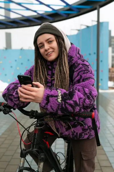 stock image European stylish woman in an informal look rides a bicycle on the street.