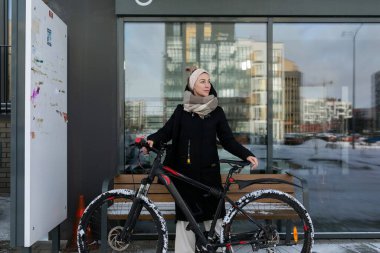 Sarışın, sırıtan sevimli bir kadın kışın bisiklet kiraladı..