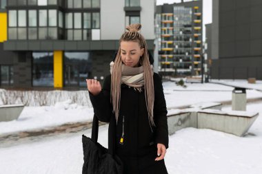 Siyah kışlık ceket giyen, sarışın, güzel bir kadın..