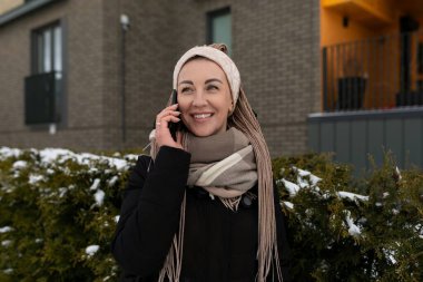 Kışın şehirde yürüyen rastalı hoş bir genç kadın..