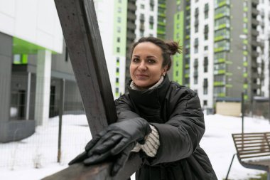 Hafta sonu konsepti, siyah kışlık ceket giymiş esmer kadın sokakta yürüyor..