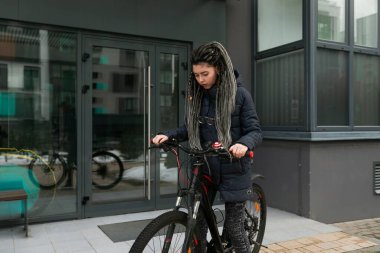 Şehirde bisiklet süren hoş, genç bir bayan..