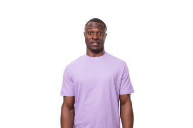 Beyaz arka planda pamuk tişört giymiş genç, karizmatik Amerikalı bir adam..