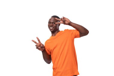 Kısa saçlı, turuncu tişörtlü genç bir Amerikalı göz kırpıyor..