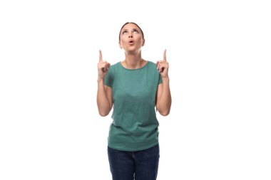 İyi giyimli, yeşil tişörtlü ve kot pantolonlu esmer kadın şaşırmış görünüyor..