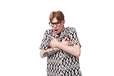 Yazın kısa kollu siyah beyaz gömlek giyen, görüş gözlüklü genç kızıl saçlı beyaz adam korku hissediyor..