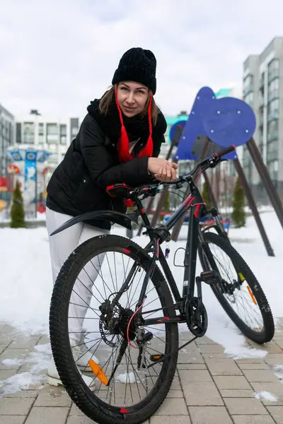 女性が冬に市内を走るために自転車を借りた — ストック写真
