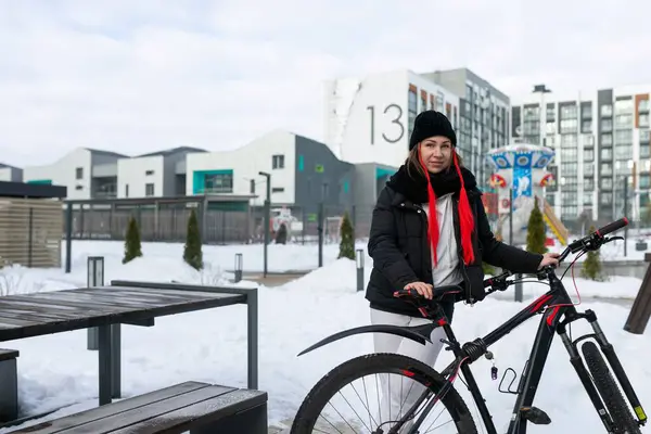 穿着冬衣的欧洲女人在冬天骑自行车 — 图库照片