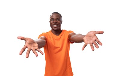 Kısa saçlı, turuncu tişörtlü genç bir Amerikalı sarılmak için kollarını uzatıyor..