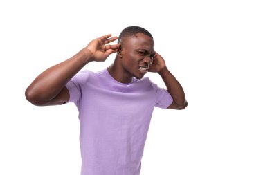 Hafif bir tişört giymiş enerjik bir Amerikalı genç adam sesi dinliyor..