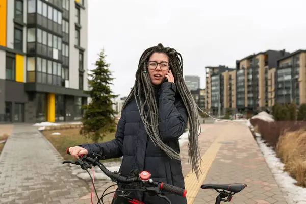 一位漂亮的年轻女子 留着可怕的发型 骑着自行车停下来休息 — 图库照片