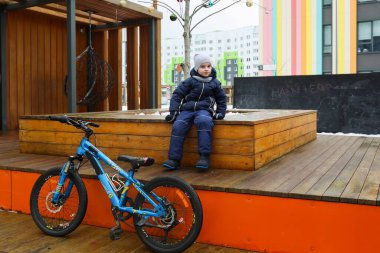 Beyaz çocuk bisiklet sürmekten yoruldu ve dinleniyor..