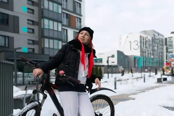 穿着冬衣的欧洲女人在冬天骑自行车 — 图库照片