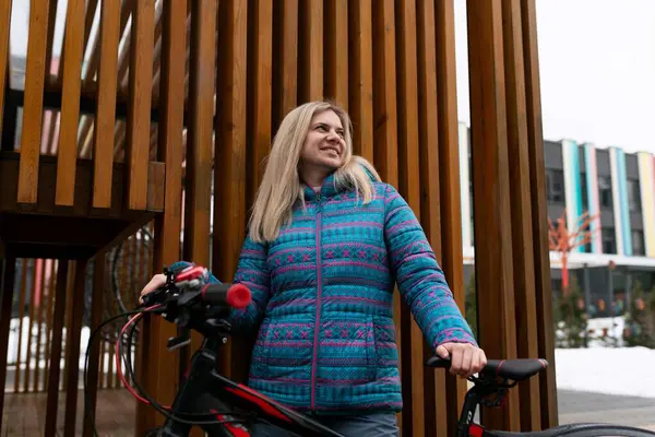 生活方式的概念 一个穿蓝色夹克的女人租了一辆自行车 — 图库照片