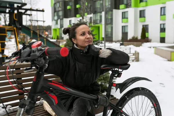 冬の路上で自転車に乗っているヨーロッパの若い女性 — ストック写真