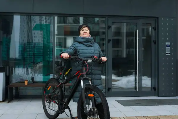 A healthy pensioner woman went for a bike ride in the cold.