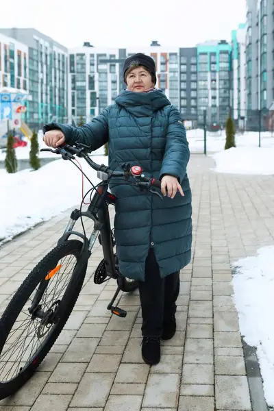 A healthy pensioner woman went for a bike ride in the cold.
