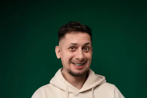 Homem Usando Capuz Branco Sorri Diretamente Para Câmera Mostrando Uma — Fotografia de Stock