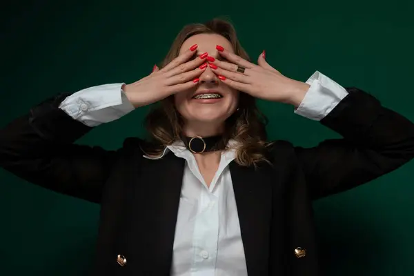 stock image A woman with long hair covering her eyes with her hands, blocking out light or shielding herself from a sight. She appears to be in a moment of introspection or shielding herself from something.