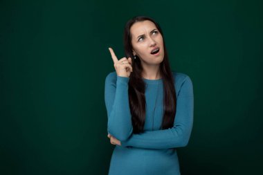 Mavi elbiseli bir kadın, barış işareti olarak parmakları V şeklinde poz veriyor..