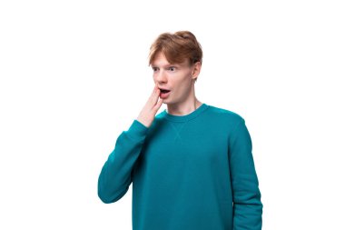 Kızıl saçlı bir öğrencinin yakın plan portresi. Mavi kazak giymiş bir adam. Yan tarafa şaşkın şaşkın bakıyor..