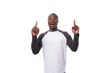 Uzun kollu kazak giyen yakışıklı Amerikalı genç adam jestler kullanarak haberleri sunuyor..