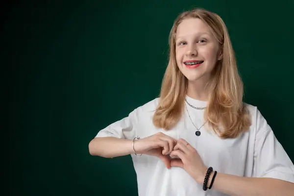 stock image A woman wearing a white t-shirt strikes a pose for a picture, looking directly at the camera with a confident expression. Her body language exudes poise and self-assurance as she stands in a casual