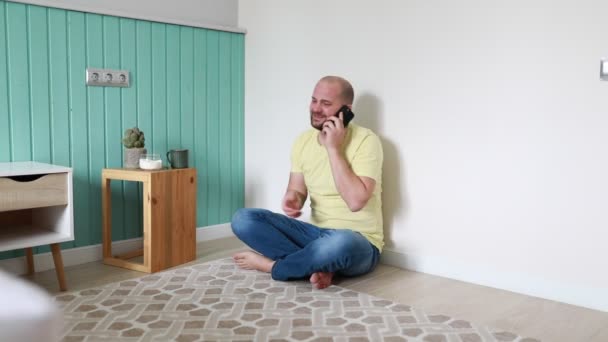 Homem Careca Alegre Senta Descalço Chão Uma Sala Estar Bem — Vídeo de Stock