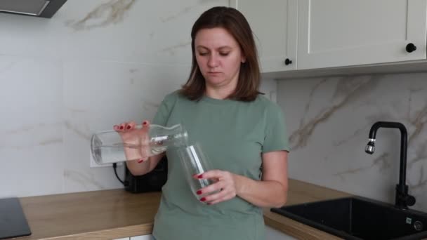 Жінка Стоїть Сонячній Сучасній Кухні Поливаючи Прозору Рідину Пляшки Металеву — стокове відео