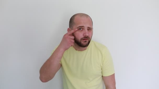 Bald Man Wearing Yellow Shirt Stands Plain Background Displaying Expressions — Stock Video