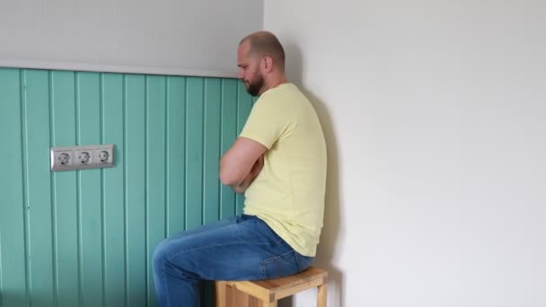 Łysy Mężczyzna Brodą Siedzi Drewnianym Stołku Skrzyżowane Ramiona Ubrany Żółty — Wideo stockowe
