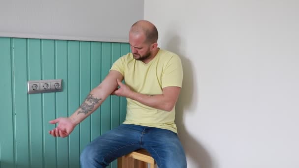 Een Kale Man Met Een Geel Shirt Zit Een Houten — Stockvideo
