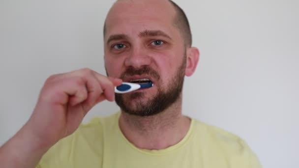 Ein Glatzköpfiger Mann Gelben Shirt Geht Seiner Täglichen Zahnhygiene Nach — Stockvideo