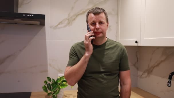 Mężczyzna Stoi Kuchni Rozmawia Przez Telefon Rozmawia Przez Telefon Komórkowy — Wideo stockowe