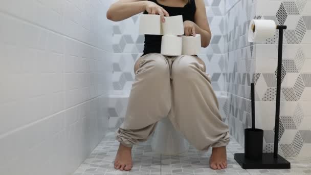 女性はトイレットペーパーのロールを自宅のトイレに貯蔵し 世界的な健康危機の間の消費者の行動を反映して不足の準備をしている — ストック動画