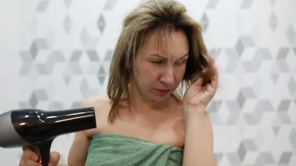 Женщина Вытирает Волосы Феном Держит Фен Одной Руке Другой Рукой — стоковое видео