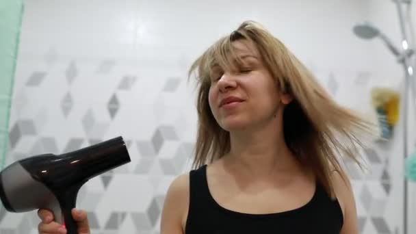 Μια Γυναίκα Στεγνώνει Μαλλιά Της Στο Μπάνιο Χρησιμοποιεί Στεγνωτήρα Μαλλιών — Αρχείο Βίντεο