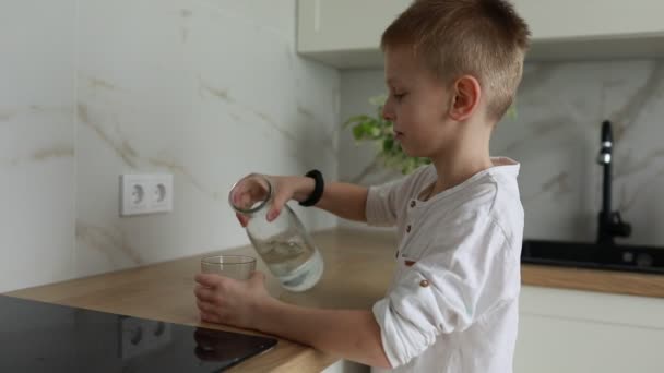 Niño Está Parado Mostrador Cocina Vertiendo Independientemente Agua Una Jarra — Vídeos de Stock