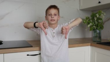 Genç bir çocuk modern bir mutfağın ortasında duruyor, çeşitli el hareketleri sergiliyor. Animasyon ifadeleri ve gelişigüzel hareketleri ilgi çekici ve kişisel bir atmosfer yaratıyor..