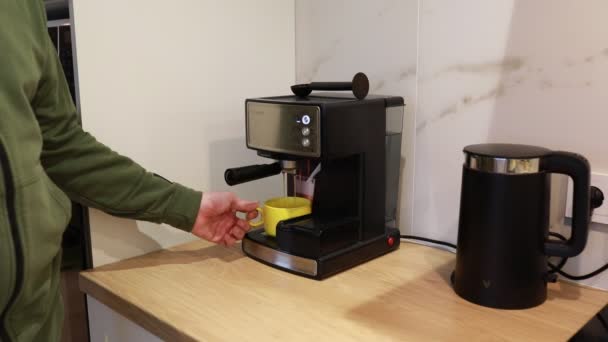 現代のエスプレッソマシンを使用して 家庭用キッチンで新鮮なコーヒーを準備しています このプロセスは 豆を粉砕し 敷地を改ざんし エスプレッソを黄色のカップに醸造することを含みます — ストック動画