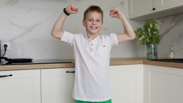 Een Jonge Jongen Staat Een Keuken Met Zijn Armen Boven — Stockvideo