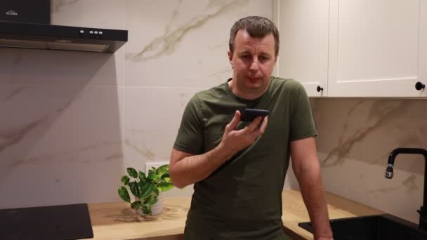 Medelålders Man Står Ett Välupplyst Kök Med Marmor Bänkskivor Hålla — Stockvideo