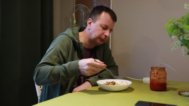 Ein Mann Sitzt Gemütlich Seinem Küchentisch Und Genießt Einen Teller — Stockvideo