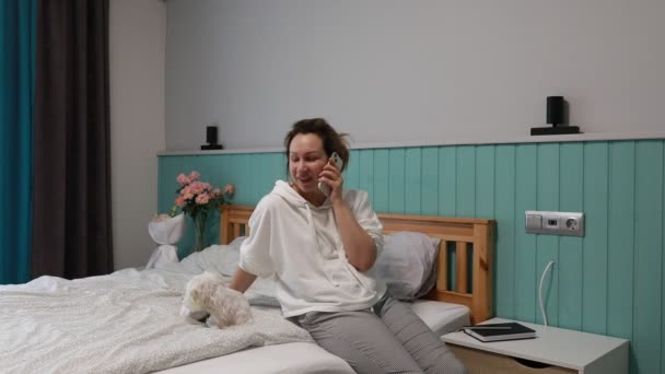 Una Mujer Disfruta Una Alegre Llamada Telefónica Sentada Cama Compartiendo — Vídeo de stock