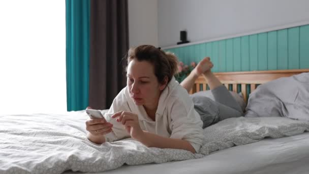 Young Woman Enjoys Leisurely Morning Reclining Her Comfortable Bed She — Stock Video