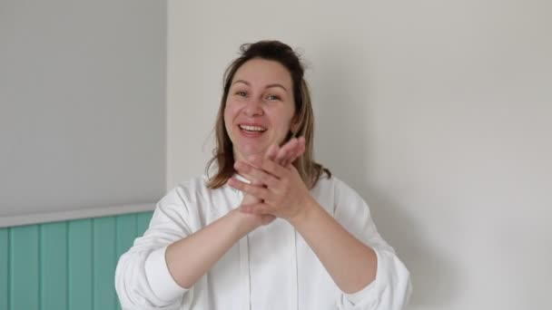 Eine Fröhliche Frau Trägt Einen Gemütlichen Weißen Kapuzenpulli Steht Vor — Stockvideo