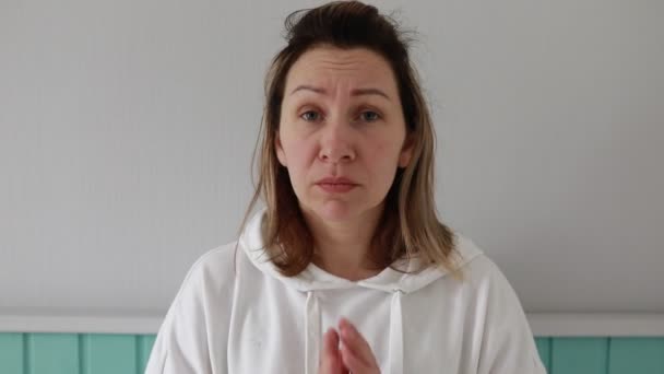Beyaz Kapüşonlu Bir Kadın Bir Deniz Mavisi Duvarına Karşı Duruyor — Stok video