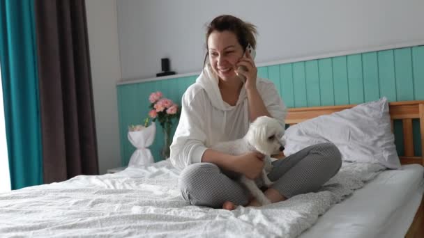 Zadowolona Kobieta Ubrana Zrelaksowany Domowy Strój Siedzi Łóżku Skrzyżowanym Nogą — Wideo stockowe