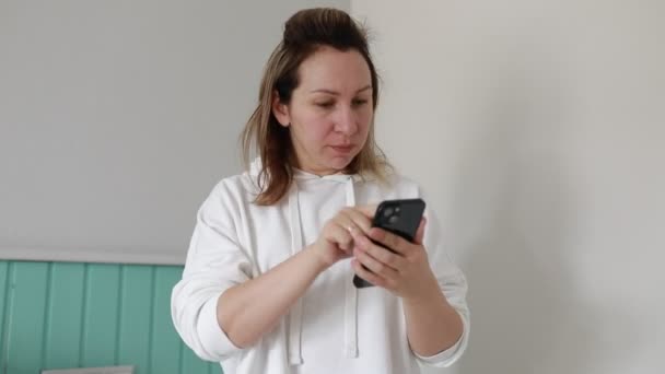 Seorang Wanita Muncul Dengan Smartphone Nya Lembut Penyadapan Dan Menggulung — Stok Video